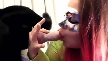 Redhead gags with a dog dick in her mouth while on cam