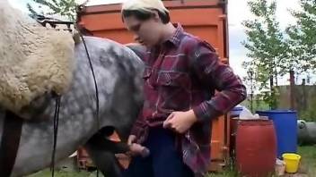 Big-breasted country girl kissing the animal's cock